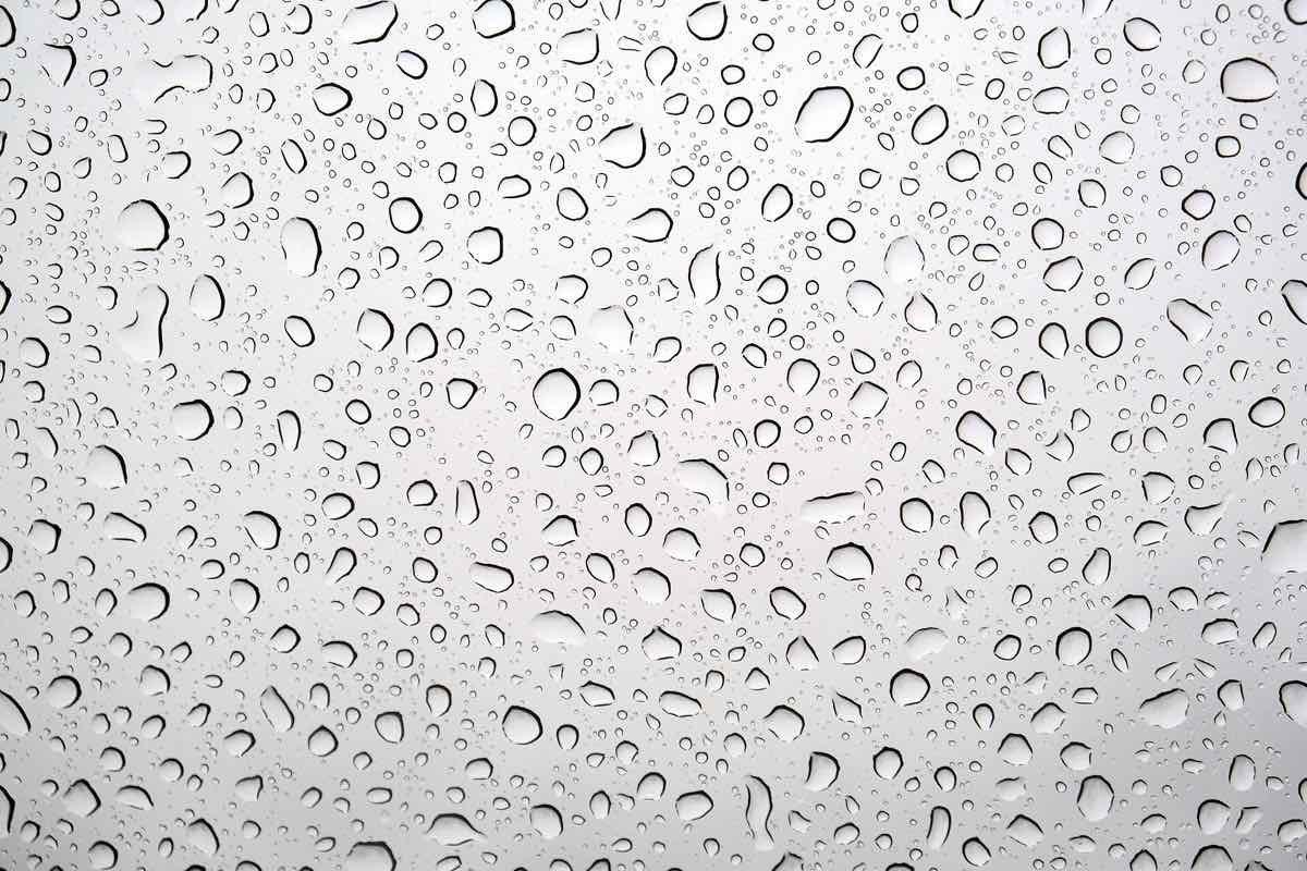 Even sheet of small water droplets beading across a light colored coated car roof