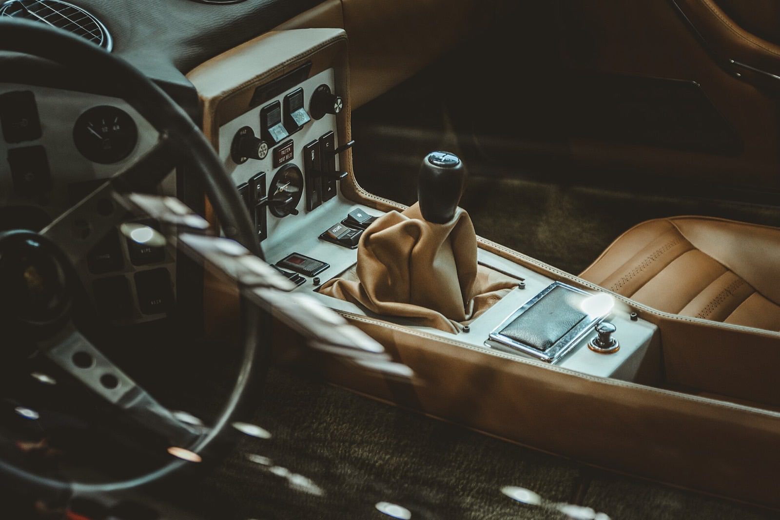 Tan leather car interior with a cleaned center console, gear lever and stitched seat bolster